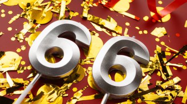 Kırmızı bayramda konfeti arkaplanlı 66 numaralı doğum günü rakamı. 66 'ncı yaş günü. Doğum günü, yıldönümü ve tarih kavramı. Boşluğu kopyala