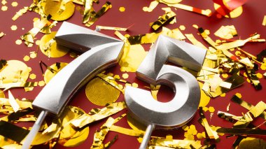 Konfeti geçmişi olan 75 numaralı kırmızı şenlik kutlamasında doğum günü rakamı. 75 'inci yaş günü. Doğum günü, yıldönümü ve tarih kavramı. Boşluğu kopyala