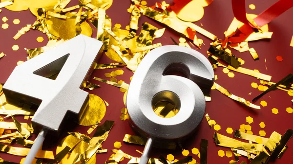 Kırmızı bayramda konfeti arkaplanlı 46 numaralı doğum günü rakamı. 46 'ncı yaş günü. Doğum günü, yıldönümü ve tarih kavramı. yakın plan