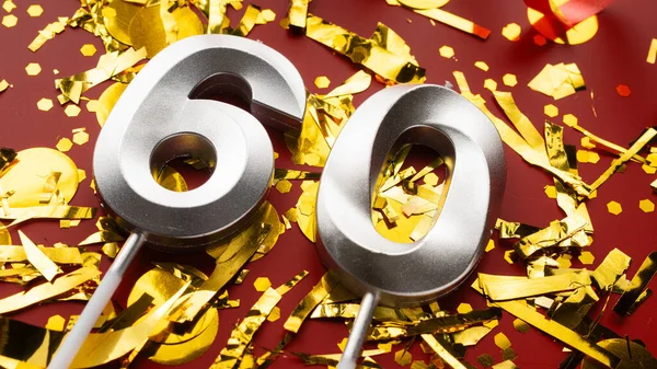 Kırmızı şenlik programında 60 numaralı doğum günü rakamı konfeti arka planında. Altmış yıllık doğum günü. Doğum günü, yıldönümü ve tarih kavramı. Boşluğu kopyala