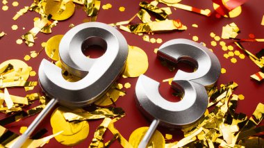 Kırmızı bayramda konfeti arkaplanlı 93 numaralı doğum günü rakamı. Doksan üç yaş günü. Doğum günü, yıldönümü ve tarih kavramı. Boşluğu kopyala