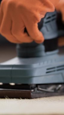 Makro elektrikli zımpara makinesinin ahşap tahtayı parlatmasını kapat. Ahşap işçiliği, mobilya üretimi ve yüzeysel üretim kavramı. Ahşap ve elektrikli aletlerin detaylı dokusu... dikey video