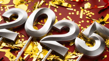 Yeni yıl kutlamaları için gümüşten 2025 numaralı konfeti ve simle hazırlanıyor. Boşluğu kopyala