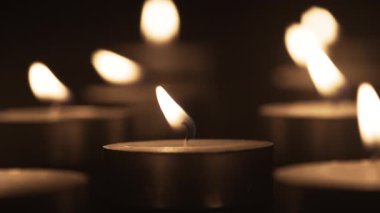 Karanlıkta parlayan gece lambası mumlarının yakın çekimi sıcak bir atmosfer yaratıyor. Mum ateşi, alev alev. Boşluğu kopyala