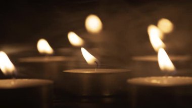 Karanlıkta parlayan gece lambası mumlarının yakın çekimi sıcak bir atmosfer yaratıyor. Mum ateşi, alev alev. Boşluğu kopyala