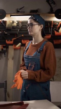 Bir tamirciye ya da turuncu koruyucu eldiven takan bir tamirciye yaklaş. İş güvenliği kavramı, işgücü koruması ve el işleri için profesyonel hazırlık. Dikey video