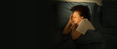 Geceleri yatağında huzur içinde uyuyan bir kadının en iyi görüntüsü. Gece ve dinlenme kavramı. en üstteki görünüm