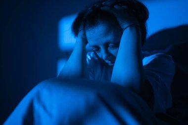 Yatakta uykusuzluk ve baş ağrısı çeken stresli bir kadın, uykusuz gecelerde depresyon ve zihinsel bozukluk hisseden bir kadın. kopyalama hızı