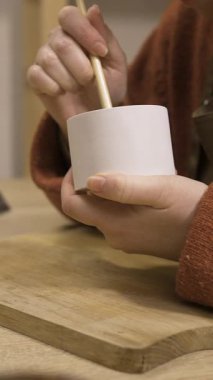 El yapımı alçıtaşı şamdanına vernik uygulayan kadın ellerini kapat, DIY ev dekorasyonu tamamlama işlemi. DIY ve hobi konsepti. dikey video