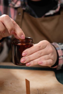 Mum imalatçısı atölyedeki cam kavanoza tahta fitil koyuyor. Aroma mumları yapıyorum. yakın plan