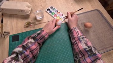Bakış açısı. Paskalya yumurtalarını boyayan kadın evde tatil yapmaya hazırlanıyor. Sanatsal ve el yapımı DIY çalışmaları.