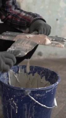 Havan ve duvar harcı karıştıran malayla inşaat işçisi, yakın plan.