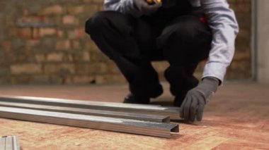 Duvarların inşası için alüminyum alüminyum profillerle çalışan bir inşaat işçisi. yakın plan