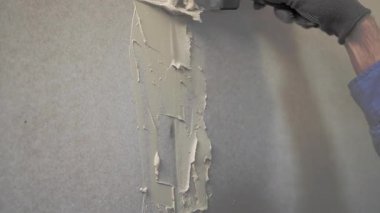 Sıvacı ellerin sıva kaplama duvara sıva yapıştırdığı yakın plan.