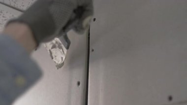 Ev yenileme konsepti. Erkek eli sıva tahtasını macun bıçağıyla sıva yaparken yakın plan..