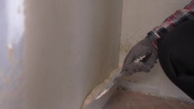 Kalın yamalı iç duvar kullanarak macun bıçağı kullanan bir işçi. Yakın plan. Ev yenileme konsepti
