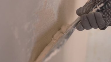 İnşaat işçisi tadilat sırasında duvara alçı yapıştırıyor. yakın plan