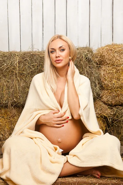 Pregnant woman relaxing sitting on hay — Stock Photo, Image