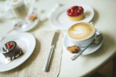fincan kapuçino ve kek masada