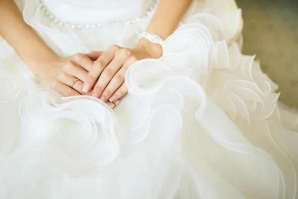 Bruiden handen op witte jurk — Stockfoto