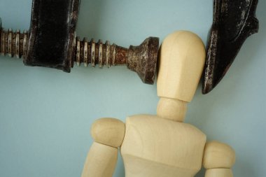 Demir mengene aletine sıkıştırılmış tahta manken heachache, stres ve psikolojik baskı kavramı