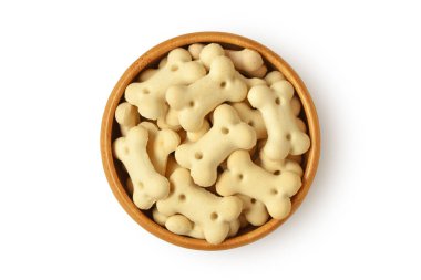 Kemik şekilli köpek bisküvileri beyaz arka planda ahşap kasede.