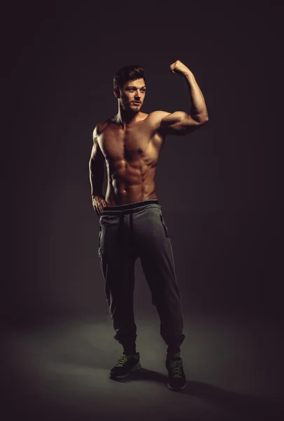 Athletic handsome man showing biceps muscles, studio shot — Stock Photo, Image