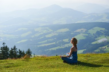 Genç kadın pratik yoga dağ tepe üzerinde