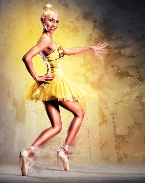 Beautiful ballerina in yellow tutu on point. — Stock Photo, Image