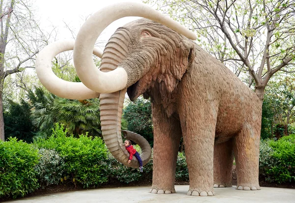 Menina deitada na probóscide de um elefante — Fotografia de Stock