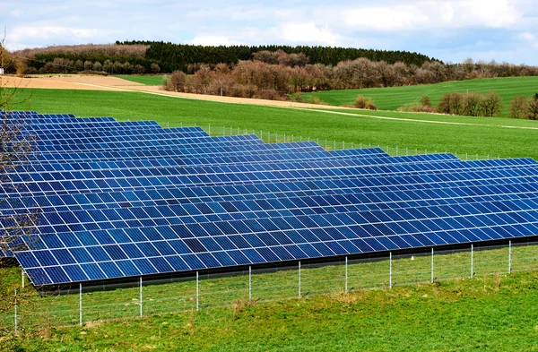 Paneles solares en un campo verde —  Fotos de Stock