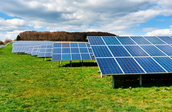 Zonnepanelen op een groen veld — Stockfoto