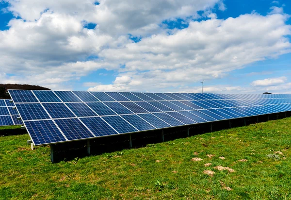 Zonnepanelen op een groen veld — Stockfoto