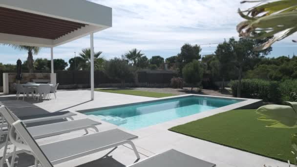 Luxus-Sommervilla mit Pool und leeren Liegestühlen in Reihe an warmen Sommertagen. Urlaub und neue Immobilien, Bankkredite, Bausparkonzept. Spanien