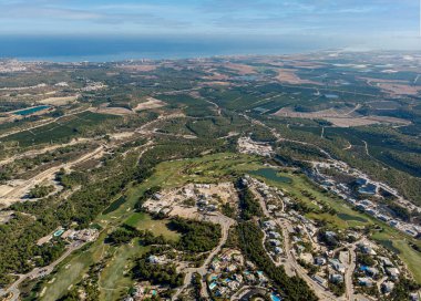 Hava fotoğrafı Las Colinas golf sahası modern lüks villalar ve çevresindeki kırsal bölge. Akdeniz kıyı şeridi uzaktaki manzarası. Costa Blanca, Alicante, İspanya