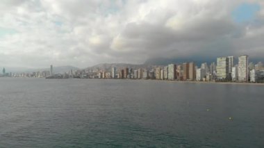 Deniz kenarındaki Benidorm kıyı şeridi, yüksek binalar modern konutlar ve ofis gökdelenleri, bulutlar, güneşli bir gün. Alicante ili, Costa Blanca, İspanya