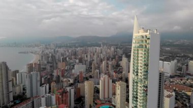 Hava bulutluyken İspanya 'nın Benidorm kentinin çatılarından insansız hava aracı bakış açısı. Modern mimari ve Akdeniz Deniz Burnu. Costa Blanca, Alicante ili. İspanya