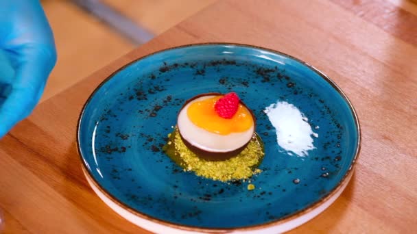 厨师用新鲜的覆盆子和蓝莓把慕斯装饰成一个巧克力半球霉菌 关门了 食肆甜点制作概念 — 图库视频影像