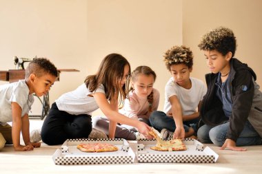 Beş sevimli çocuk, küçük kız ve erkek içeride oturup İtalyan usulü pizza yiyor. Alfa nesli paylaşır, birlikte zaman geçirir. Arkadaşlık, yemek zamanı konsepti.