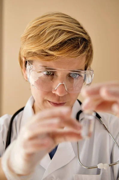 Vrouwelijke Verpleegkundige Draagt Een Witte Vacht Beschermende Handschoenen Glazen Injectieflacon — Stockfoto