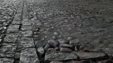 Taşıyıcı kamera Toledo şehrinin turistik yerindeki boş kaldırım taşı caddesini gösteriyor. İnsan yok, gri ve siyah renkler. İspanya