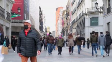 Madrid, İspanya - 5 Mart 2021 Calle Preciados 'un işlek caddesi. Corona virüsü yüzünden maske takan kalabalık Covid-19 Madrid 'in ana alışveriş caddesi boyunca yürüyor. İspanya