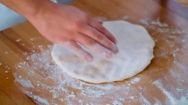 Merdaneli hamur hamuru kullanarak pizza yapan erkek elleri kapatın. Gıda hazırlama süreci.