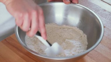 Mutfak spatulasını tutan erkek şef kapta un karıştırıp hamur işi hazırlıyor. Pizza hazırlama süreci kavramı