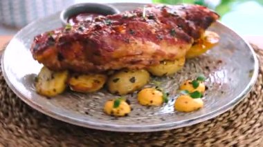 Patatesle süslenmiş domuz pirzolası servis edilir, yakın görüş. Hareketli yemek konsepti