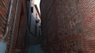 Güneşli bir günde eski Toledo şehrinin büyüleyici dar sokakları. Boş yaya geçidi ve konut manzaralı duvarlar. İnsan yok. İspanyol simgeleri, seyahat konsepti. Castilla-La Mancha, İspanya
