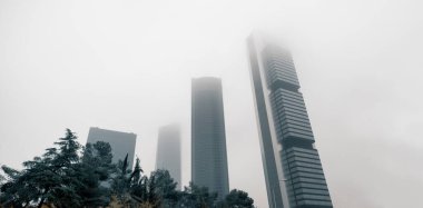 Sisli havada modern gökdelenlerin mimari manzarası. Sisli gökyüzüne karşı Dört Kuleler İş Alanı. Paseo de la Castellana 'da bulunan iş bölgesi Madrid, Avrupa, İspanya
