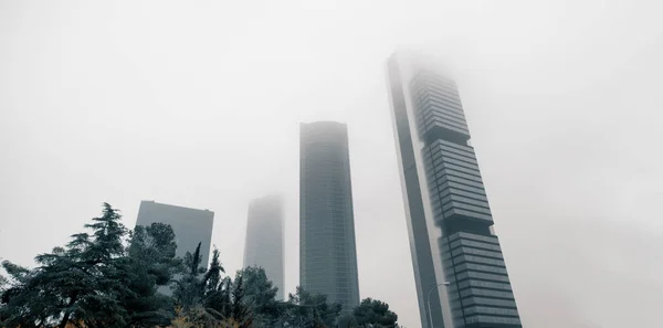 霧の多い天候の中で現代の高層ビル建築ビュー 4つのタワービジネスエリア霧の空に対して スペイン ヨーロッパ マドリードのPaseo Castellanaに位置するビジネス地区 — ストック写真