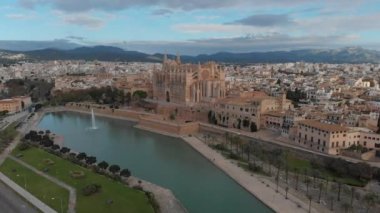 Palma de Mallorca şehir manzarası. La Almudaina 'daki Santa Maria Kraliyet Sarayı' ndan La Seu Katedrali, güneşli bir günde eski bir mimari drone. Seyahat, dönüm noktası, ünlü bir yer. Balear Adaları. İspanya