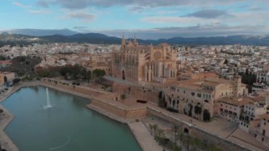 Palma de Mallorca şehir manzarası. La Almudaina 'daki Santa Maria Kraliyet Sarayı' ndan La Seu Katedrali, güneşli bir günde eski bir mimari drone. Seyahat, dönüm noktası, ünlü bir yer. Balear Adaları. İspanya